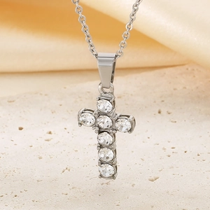 Macro shot of silver titanium steel cross pendant necklace with six sparkling crystals