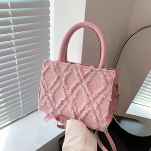 Pink large capacity quilted tote bag with fringe texture shown held by hand