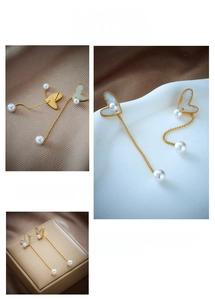 Detail of heart shell earrings with golden chain tassels and hanging white pearls