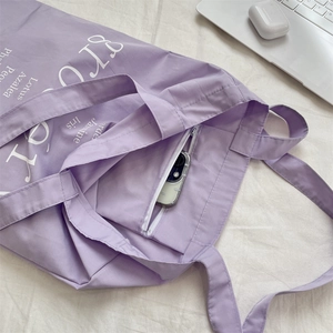 Détail du sac fourre-tout en toile violette avec poche intérieure zippée et imprimés
