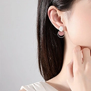 Macro detail of geometric earring with pink and white panels on a female model