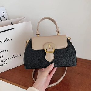 Detailansicht der Handtasche im Color-Block-Design mit Ledertextur und Goldschnalle