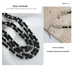 Detail of beaded necklace featuring black bamboo beads and silver clasp mechanism