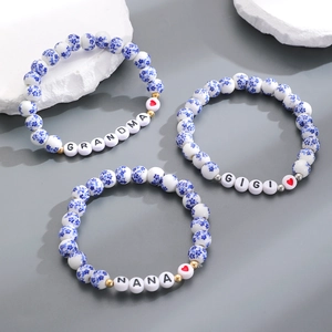 Dettaglio di braccialetti in ceramica blu e bianca con scritte Grandma Gigi Nana