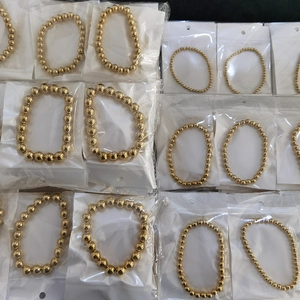 Detailed view of assorted gold beaded elastic bracelets in various bead sizes and packaging