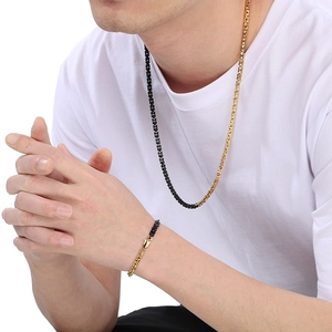 Detail view of two-tone black and gold stainless steel chain necklace and bracelet set