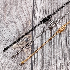 Close-up of black, silver, and gold titanium steel sweater chains with spring clasps