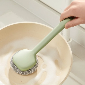 Long handle dish brush with steel wire head cleaning a non-stick pan with soapy foam