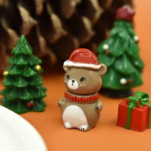 Close-up of a resin Christmas bear figurine with a red hat and scarf on a warm background