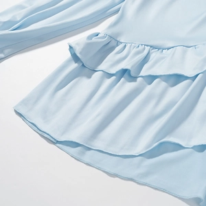 Detail of light blue bohemian two-piece set featuring ruffled edges and soft fabric