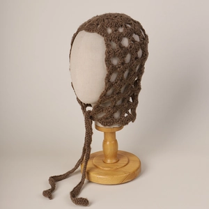 Detail of a brown mohair crochet knit hood with large mesh hollow design and long ties