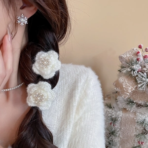 Détail d'une pince à cheveux fleur blanche tricotée avec perles et strass sur un mannequin