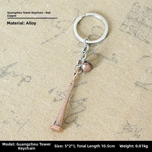 Detail of vintage copper alloy Canton Tower keychain with small bell on linen fabric