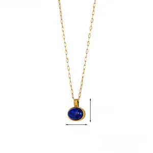 Detail of vintage lapis lazuli oval pendant with golden paperclip chain and engraving