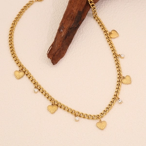 Vue détaillée du collier à maille gourmette dorée avec pendentifs cœur et strass brillants