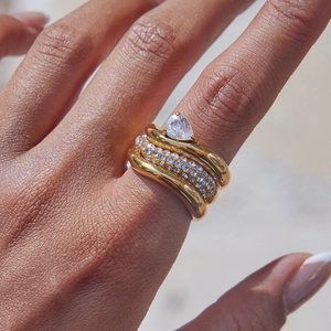 Macro shot of a stacked 3-piece gold ring set featuring pear-cut and pavé cubic zirconia