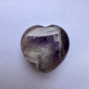 Detailed view of a 3cm heart-shaped purple crystal with polished natural stone texture