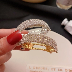 Détail de pinces à cheveux scintillantes en strass coloris argent et doré