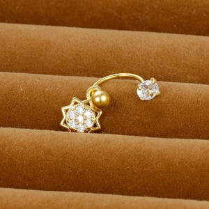 Macro shot of gold-plated C-shape cartilage stud with sun-shaped zircon pendant