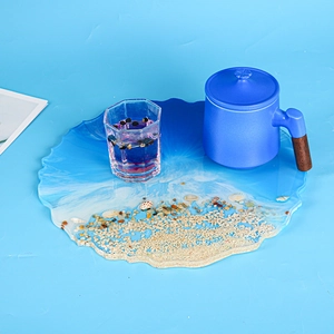 Close-up of ocean-themed resin tray with blue gradient waves and real shells sand decor
