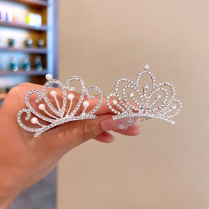 Detail shot of elegant silver crown hair clips with sparkling rhinestones and pearls