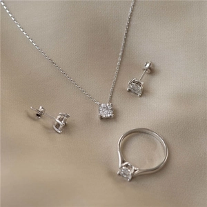 Macro shot of S925 sterling silver geometric square diamond jewelry set on silk