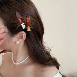 Detail of tortoise shell acrylic hair clips with colorful rhinestones on a female model