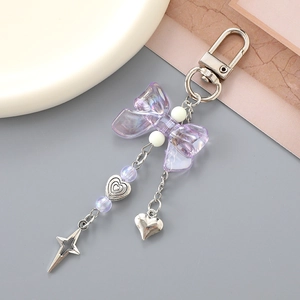 Detailed view of a purple bow keychain with heart charms and beads for bags and phones
