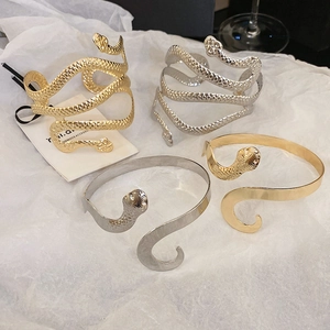 Vue détaillée de bracelets serpent en finitions or et argent avec des textures embossées
