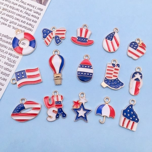 Flat lay of 14 DIY enamel American flag charms in red, white, and blue for jewelry making