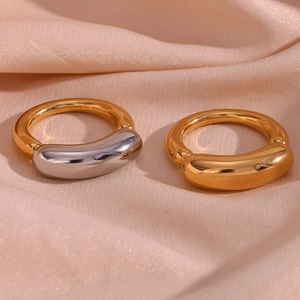 Macro shot of 18K gold plated thick smile ring on soft pink silk background