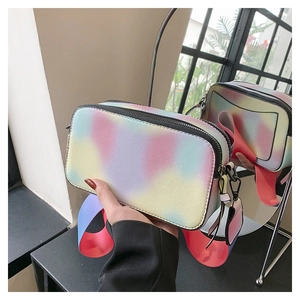 Macro shot of gradient camera bag featuring crosshatch texture and colorful wide strap