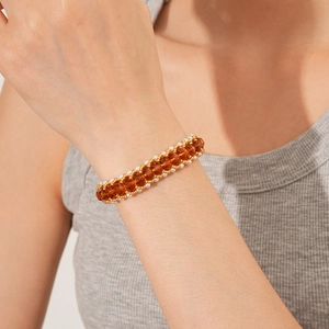 Close-up of vintage pearl and amber bead woven bracelet worn on a model's wrist