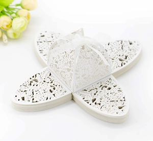 Macro detail of white laser-cut rose hollow candy box with elegant ribbon bow