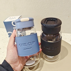 Detail of minimalist glass water bottle with blue leather sleeve and easy-carry handle
