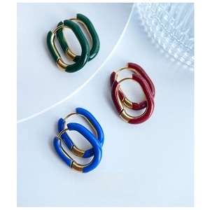 Detailed close-up of U-shaped enamel hoop earrings in gold plated stainless steel