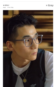 Side view of a male model wearing large square grey translucent glasses frames