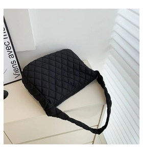 Detailed close-up of black quilted nylon texture on a large puffy cloud hobo shoulder bag