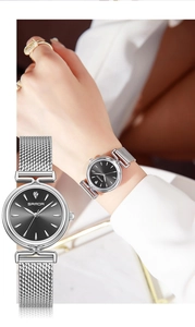 Detail of silver mesh strap watch with black dial and crystal marker on woman wrist