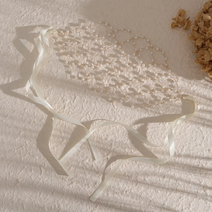 Détail du bandeau de mariée en résille fait main avec perles et longs rubans de satin