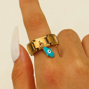 Makro-Detail des goldenen modularen Stretch-Rings mit blauem Hamsa-Hand-Emaille-Anhänger