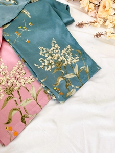 Close-up of elegant floral print on silk-like pajama set in dark green and soft pink