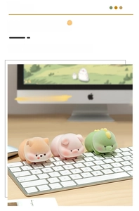 Close-up of cute fuzzy animal figurines including dog, pig and dinosaur on a laptop