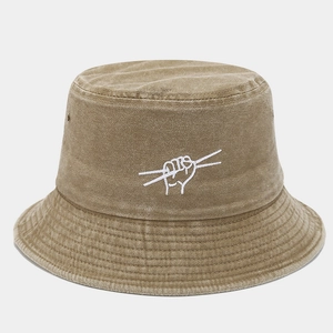 Detail of washed khaki bucket hat showing artistic hand gesture embroidery and metal eyelets