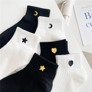 Detailed close-up of cotton socks with embroidered moon, star, and heart patterns