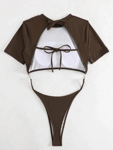 Detail of dark brown cutout swimsuit featuring back bow tie and metal ring connector