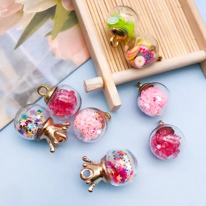 Close-up of glass wishing bottle charms with colorful star sequins and fruit fillings