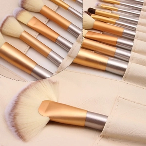 Detail of professional makeup brush set with gradient bristles and beige storage roll bag