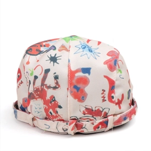 Detail of off-white canvas docker hat with vibrant colorful graffiti and cartoon prints