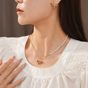 Detail of vintage zircon pony jewelry set with pearl necklace and matching earrings